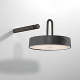 Moderne Wandleuchte ARMA in seitlicher Perspektive mit rundem, schwarzem Gehäuse und integriertem Schalter.