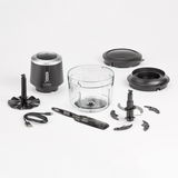 Akku-Multizerkleinerer mit Zubehör aus der Vogelperspektive, bestehend aus einem Glasbehälter, verschiedenen Klingenaufsätzen, einem schwarzen Motorblock und einem USB-Ladekabel.