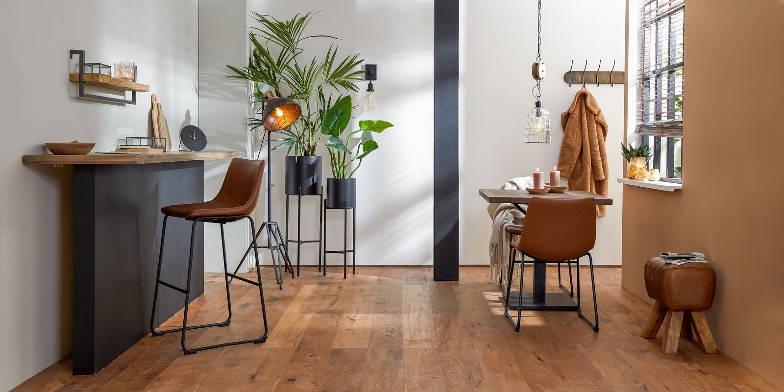 Moderner Hocker aus braunem Leder mit Holzbeinen, seitlich in einem stilvoll eingerichteten Raum platziert.