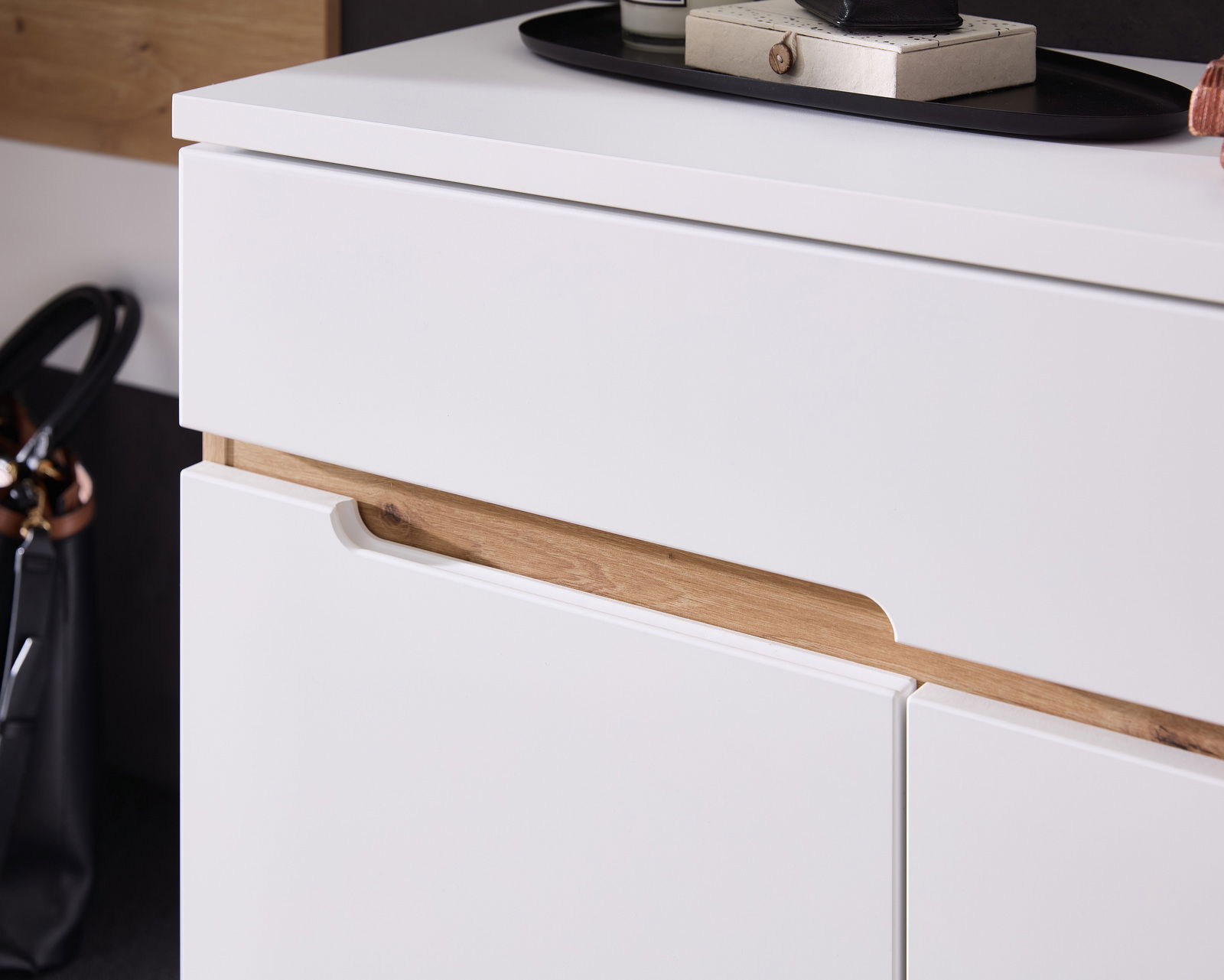 Nahaufnahme eines modernen weißen Schranks mit Holzdetails, seitliche Perspektive