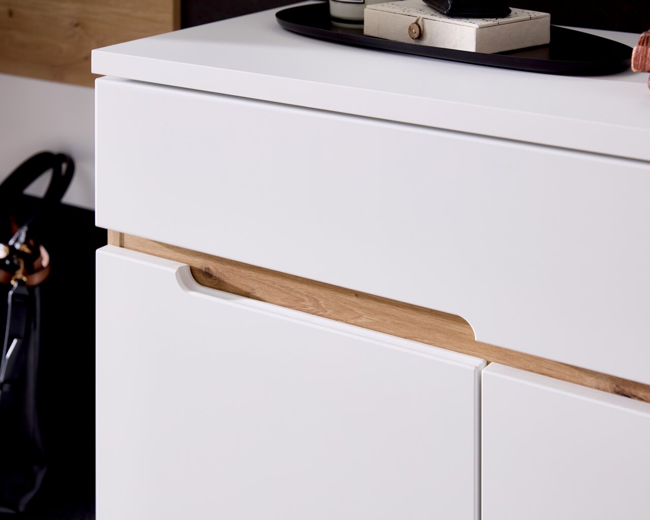 Nahaufnahme eines modernen weißen Schranks mit Holzdetails, seitliche Perspektive