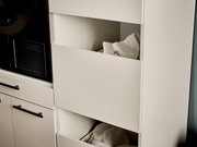 Geöffnete weiße Schubladen eines modernen Badezimmerschranks mit gefalteten Handtüchern, seitliche Nahaufnahme aus leicht schräger Perspektive