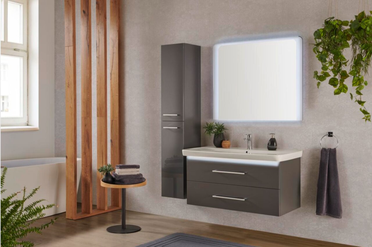 Moderne badkamercombinatie met verlichte spiegel, grijze wastafel en hoge kast, zijaanzicht.