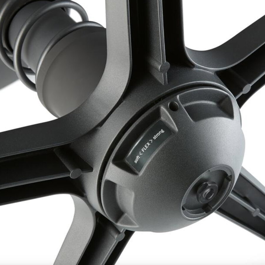 Nahaufnahme der Unterseite eines Drehstuhls mit Fokus auf die Federmechanik und Flexibilitätsanpassung.