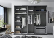 Moderne hangkast met drie deuren, open perspectief, toont het interieur met kledingstangen, planken en lades, gevuld met kleding en textiel.