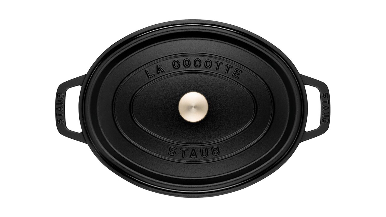 Staub Bräter Cocotte 33cm oval Schwarzer ovaler Bräter Cocotte von oben mit zwei Griffen und einem runden Knauf auf dem Deckel.