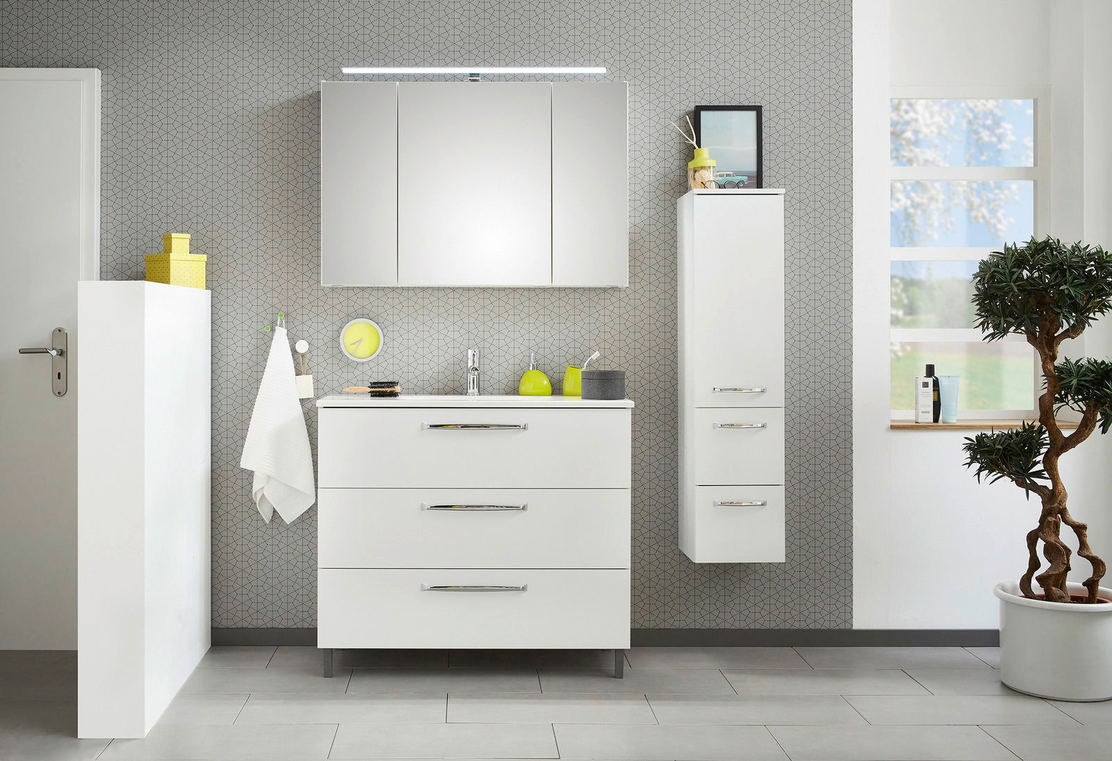 Moderne Badezimmermöbel in Weiß, bestehend aus einem Waschtischunterschrank, einem Spiegelschrank und einem Midischrank, frontal abgebildet.