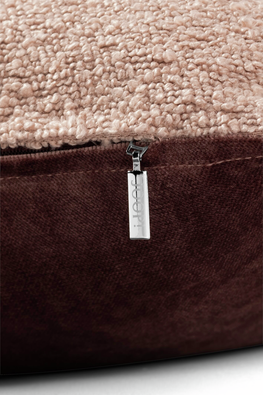 Nahaufnahme einer Zierkissenhülle mit beigem, strukturiertem Stoff und braunem Reißverschluss, seitliche Perspektive