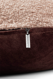 Nahaufnahme einer Zierkissenhülle mit beigem, strukturiertem Stoff und braunem Reißverschluss, seitliche Perspektive