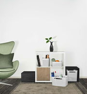 Weiße Aufbewahrungsboxen in einem modernen Wohnzimmerregal, seitliche Perspektive