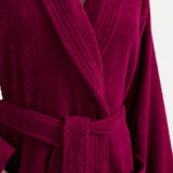 Nahaufnahme eines weinroten Bademantels mit Schalkragen und Gürtel, Vorderansicht