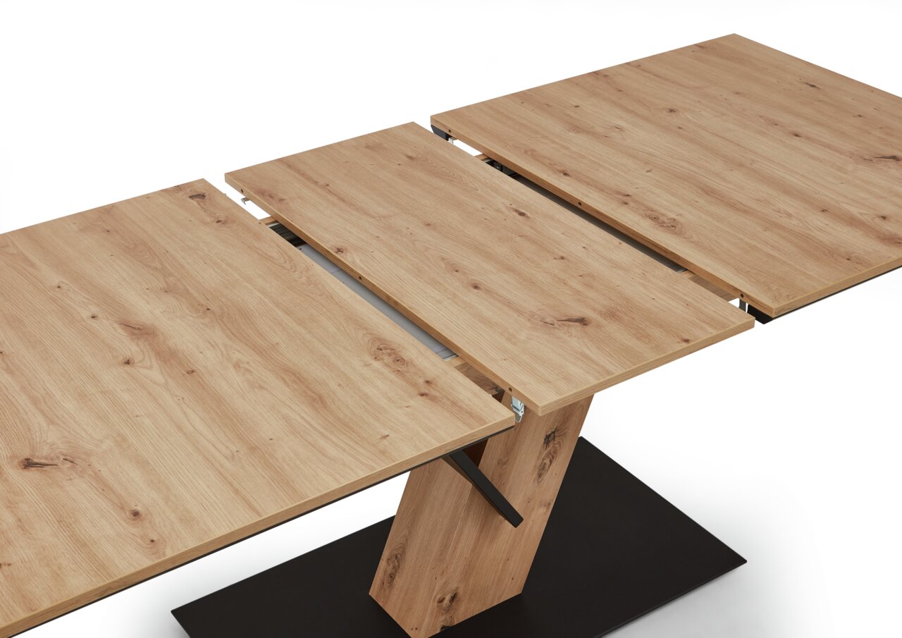 Erweiterbarer Esstisch aus Holz in heller Eichenoptik, perspektivisch von oben fotografiert, mit schwarzem Sockel.