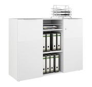 Weißes Sideboard mit zwei Türen und offenen Regalfächern, gefüllt mit Aktenordnern und Zeitschriften, seitliche Perspektive