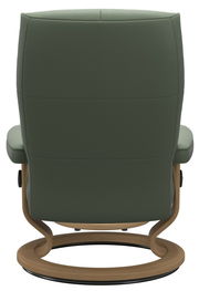 Rückansicht eines grünen Einzelsessels mit Holzgestell und rundem Fuß.