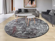 Runder Designer Teppich in einem modernen Wohnzimmer mit grauen Sofas und einem Couchtisch, aus der Vogelperspektive betrachtet.