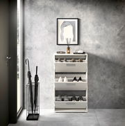 Moderner Schuhkipper mit drei Klappen, gefüllt mit Schuhen, in einem stilvollen Eingangsbereich, frontal betrachtet.