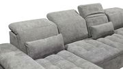 Graues Sofa mit verstellbaren Kopfstützen und Kissen, seitliche Perspektive