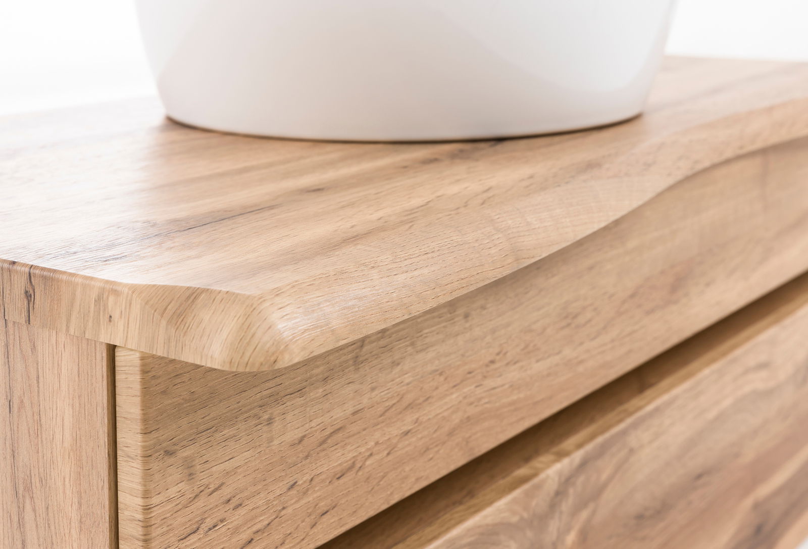 Nahaufnahme eines Waschtisch-Sets aus Holz mit abgerundeten Kanten, von der Seite betrachtet.