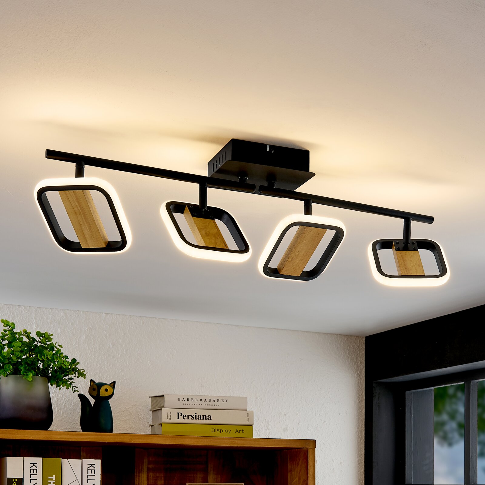 Moderne LED-Deckenleuchte mit vier rechteckigen Strahlern, Holz- und Metallelemente, Perspektive von unten.