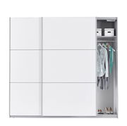 Moderner weißer Schwebetürenschrank mit zwei Türen, teilweise geöffnet, zeigt Innenraum mit Kleiderstange, Kleidung und Aufbewahrungsboxen, frontale Perspektive.