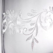 Nahaufnahme eines Bechers mit romantischem, floralen Muster in Weiß auf transparentem Hintergrund.