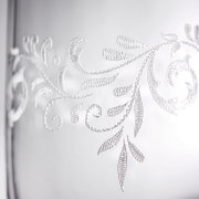 Nahaufnahme eines Bechers mit romantischem, floralen Muster in Weiß auf transparentem Hintergrund.