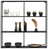 Schwarzes Wandregal mit dekorativen Objekten, darunter Vasen, Bücher, Pflanzen und eine goldene Feder, frontal betrachtet.