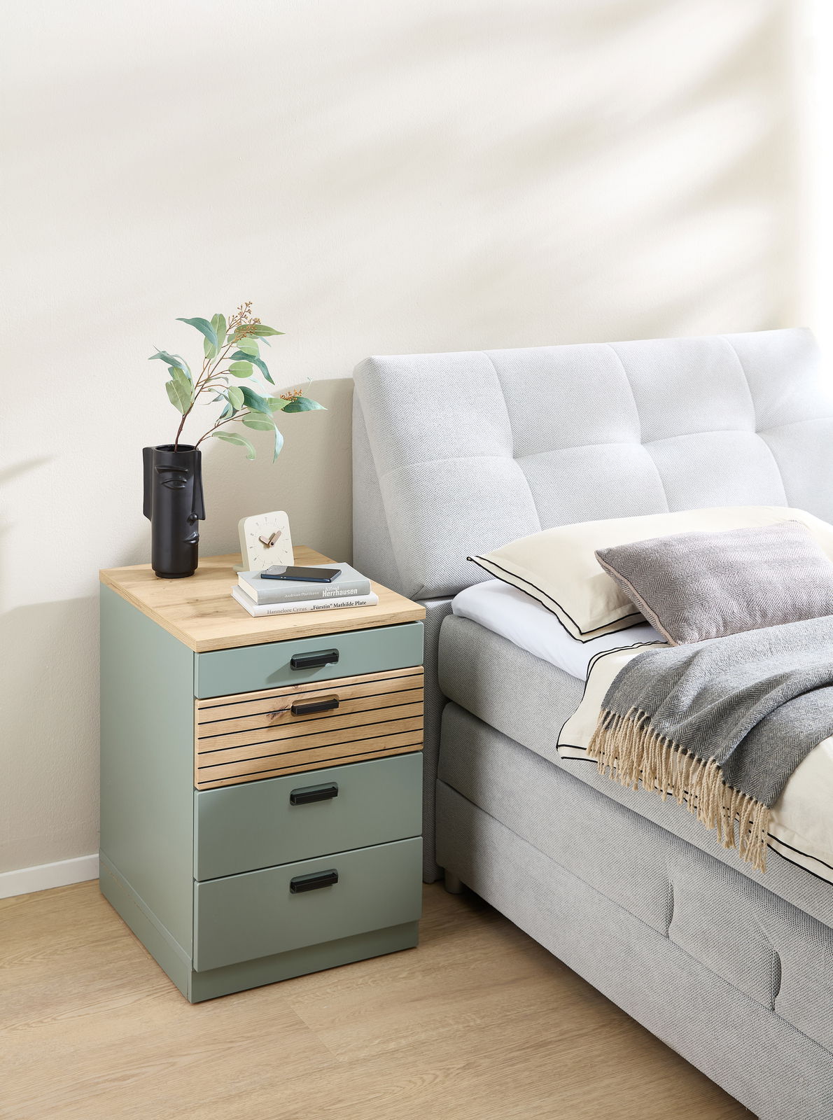 Rollcontainer mit drei Schubladen in einem modernen Schlafzimmer, seitliche Perspektive