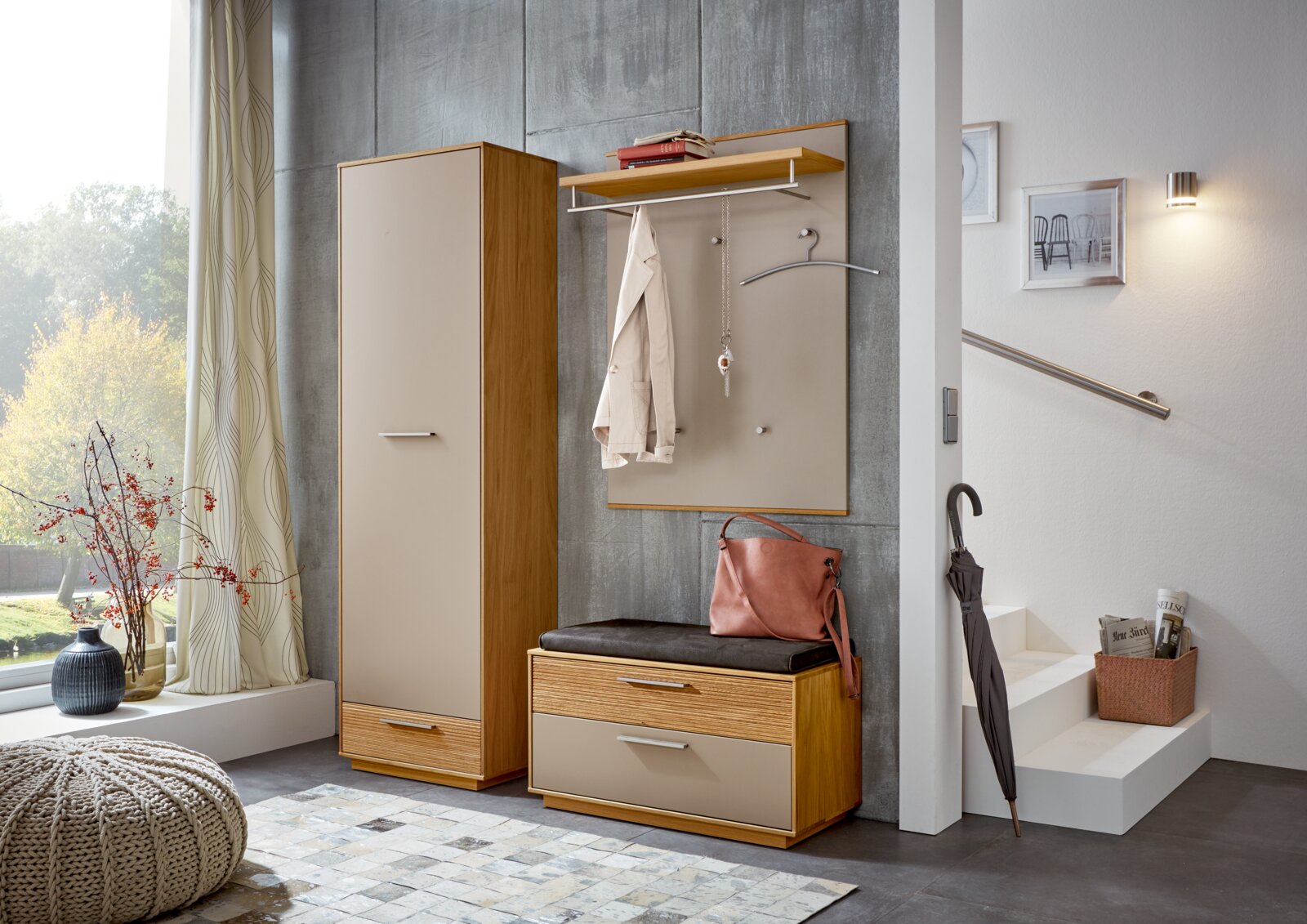 Modernes Garderoben-Set im Flur mit hoher Schrankgarderobe, Sitzbank mit Polster und Wandpaneel mit Ablage und Haken in Holz- und Beige-Optik, aufgenommen in frontaler Perspektive leicht von links.