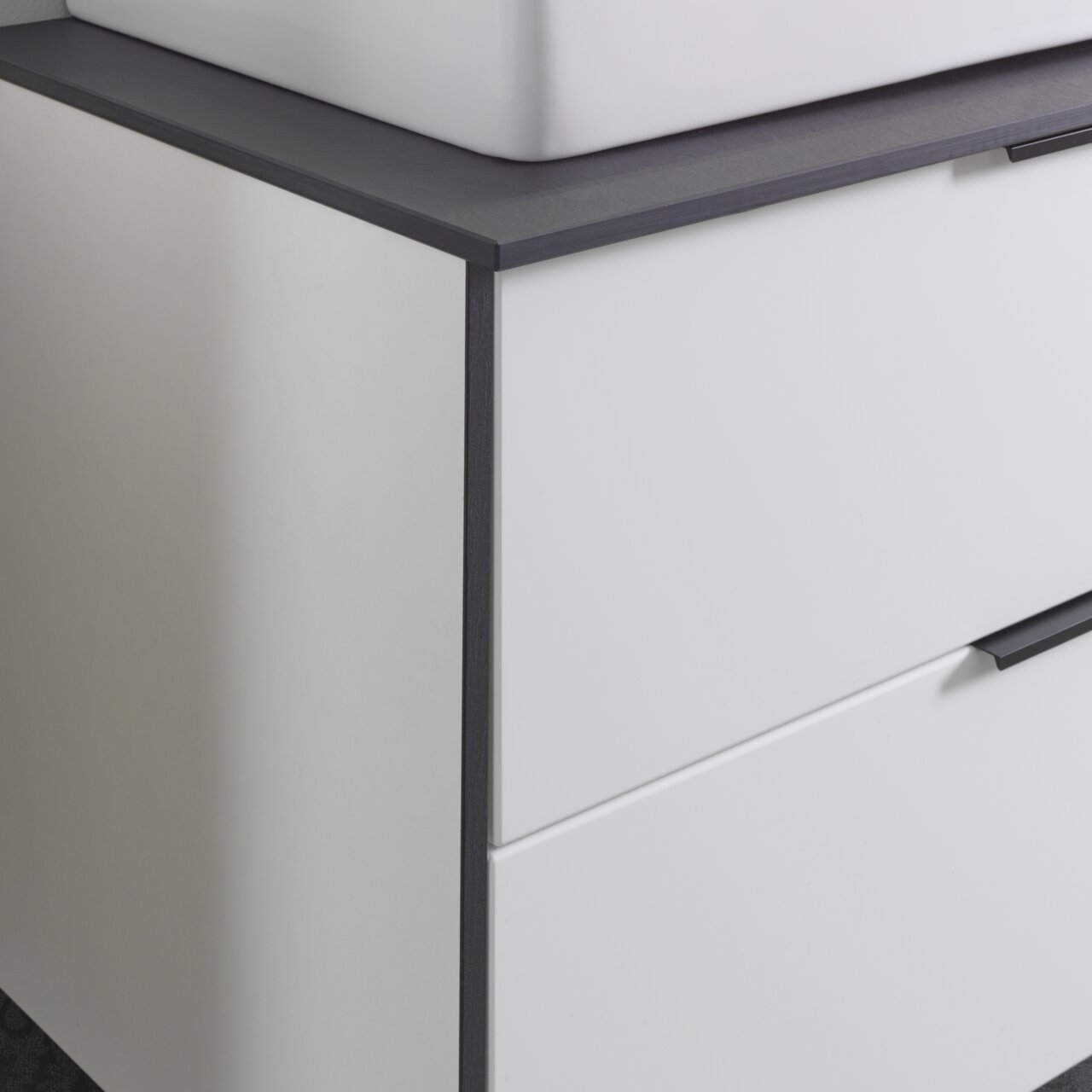 Voleo Waschtisch-Set STELLA Nahaufnahme eines modernen Waschtisch-Sets mit weißem Schrank und dunkler Arbeitsplatte, seitliche Perspektive