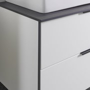 Nahaufnahme eines modernen Waschtisch-Sets mit weißem Schrank und dunkler Arbeitsplatte, seitliche Perspektive