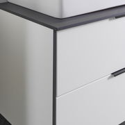 Nahaufnahme eines modernen Waschtisch-Sets mit weißem Schrank und dunkler Arbeitsplatte, seitliche Perspektive