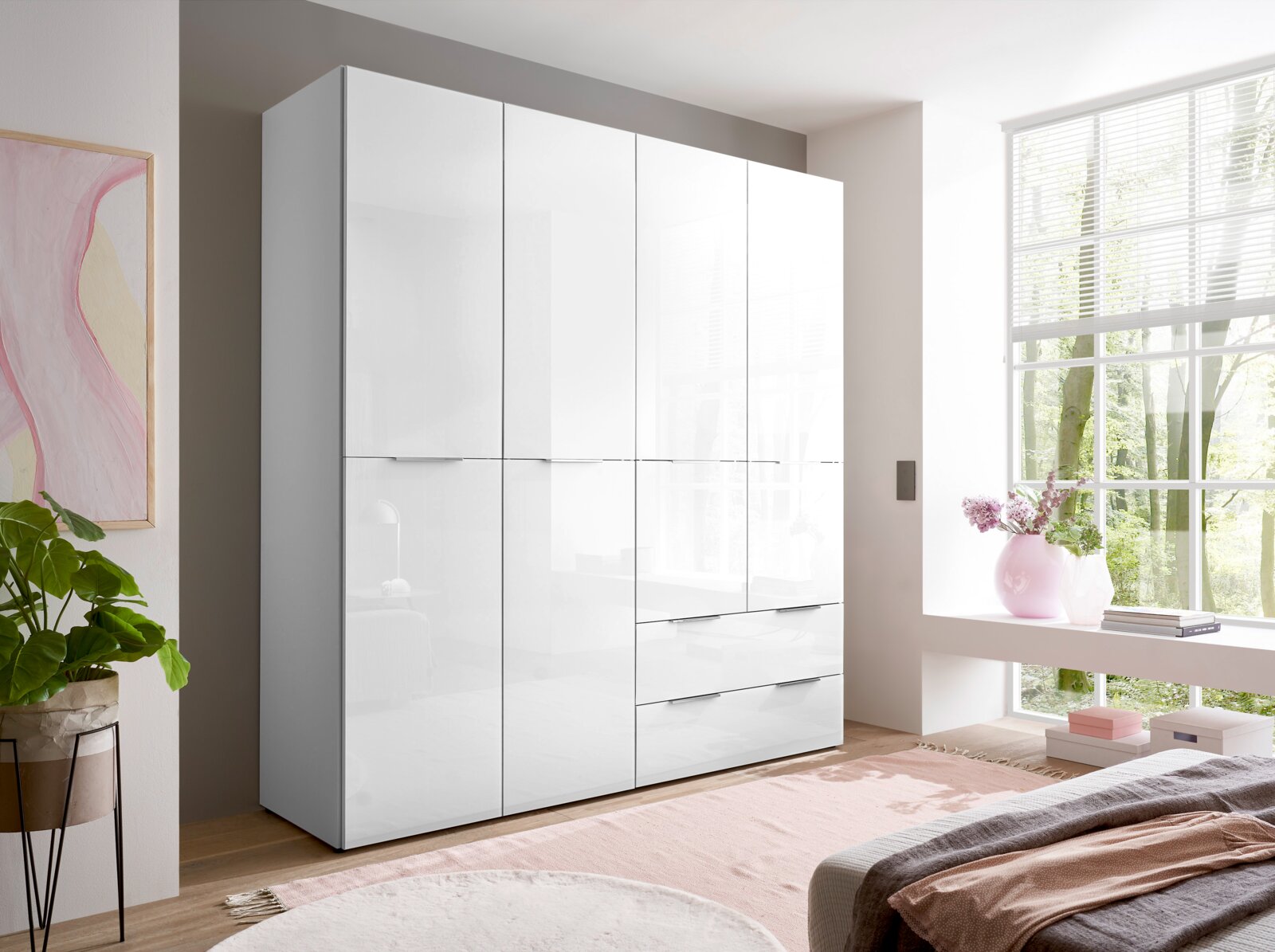 BOXXX Drehtürenschrank SANTORINI Moderner weißer Kleiderschrank mit hochglänzenden Fronten, mehreren Türen und Schubladen im hellen Schlafzimmer, fotografiert in leichter Front-Links-Perspektive.