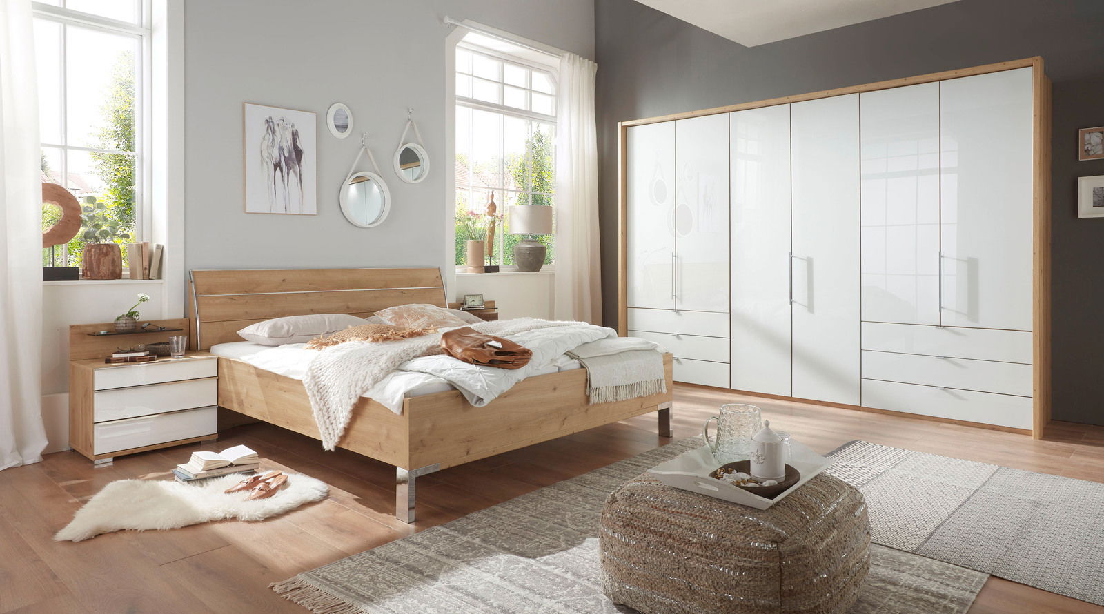 Schlafzimmeransicht mit Futonbett aus Holz, Nachtschrank-Set und großem Falttürenschrank, seitliche Perspektive.