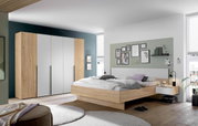 Moderne slaapkamer in hout- en wittinten, met een grote kledingkast en een tweepersoonsbed met nachtkastjes, gezien vanuit de hoek van de kamer.