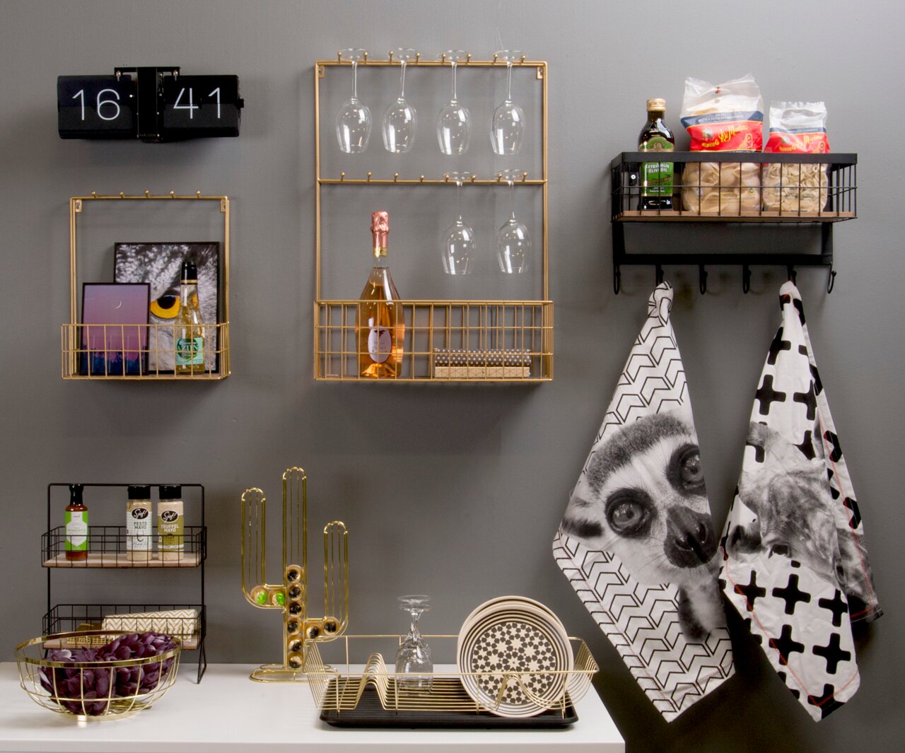 Wandklok Flip No Case in een moderne keukensetting, aan de muur bevestigd, met gouden planken en keukengerei op de achtergrond, gezien vanuit een vooraanzicht.
