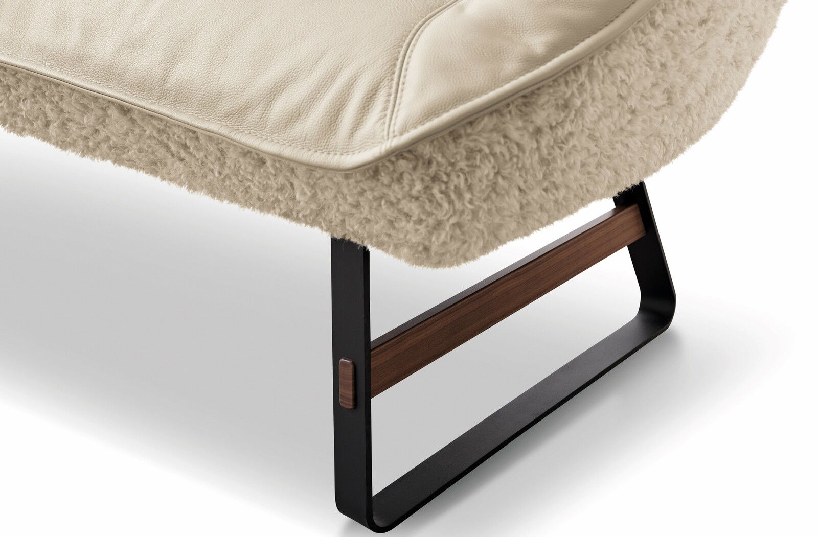 Detailansicht einer Bank mit cremefarbenem Lederpolster und flauschigem Stoffbezug, Metallbeine mit Holzelementen.