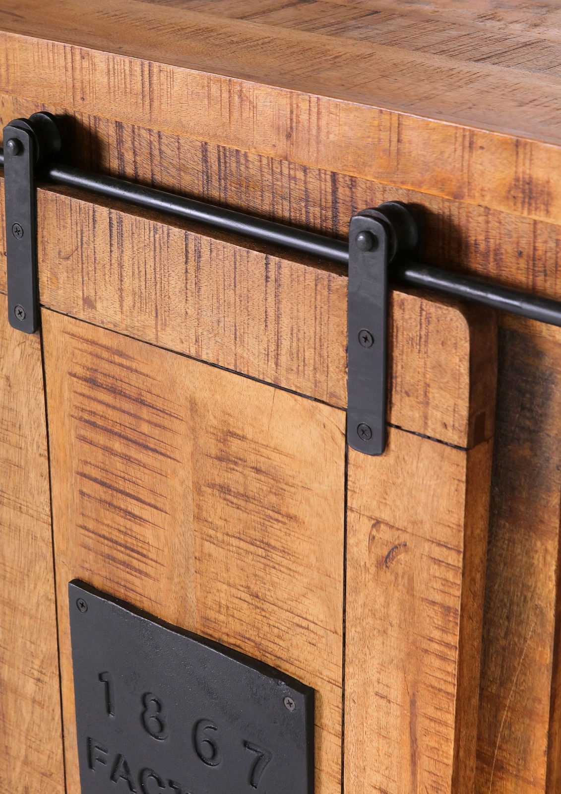 Nahaufnahme eines rustikalen Barschrankes aus Holz mit schwarzem Metallschiebemechanismus und dekorativer Metallplatte mit der Aufschrift '1867'.