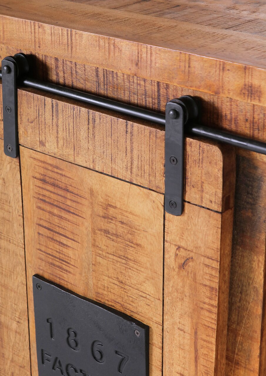 Nahaufnahme eines rustikalen Barschrankes aus Holz mit schwarzem Metallschiebemechanismus und dekorativer Metallplatte mit der Aufschrift '1867'.