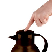 Nahaufnahme einer braunen Isolierkanne Samba QP 1,0l mit einem Finger, der auf den Deckel drückt.