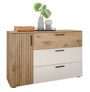 Kommode mit Holz- und weißen Elementen, drei Schubladen und einer Tür, dekoriert mit Büchern und Vasen, aus seitlicher Perspektive.