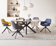 Moderner Esstisch mit schwarzem Metallgestell und heller Tischplatte, umgeben von bunten Stühlen in einem stilvollen Esszimmer, seitliche Perspektive.