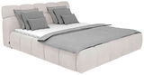 Polsterbett in seitlicher Perspektive mit grauen Kissen und Decke