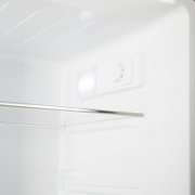 Innenansicht eines weißen Kühlschranks mit LED-Innenbeleuchtung und Temperaturregler-Drehknopf, schräg von vorne oben fotografiert