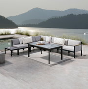 Moderne Lounge-Möbel auf einer Terrasse mit Seeblick, bestehend aus einem Ecksofa, einem Gartentisch und einem Beistelltisch, von vorne betrachtet.