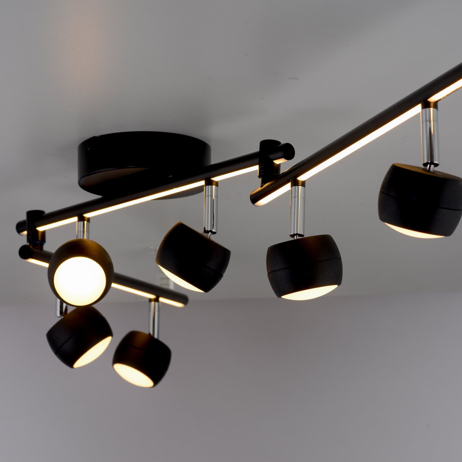 Moderne Deckenleuchte mit mehreren verstellbaren Strahlern in schwarzem Design, seitliche Perspektive.