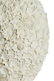 Nahaufnahme einer Vase mit detailliertem Blumenrelief in Weiß, seitliche Perspektive