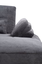 Nahaufnahme einer grauen, gerippten Rundecke mit Kissen, seitliche Perspektive