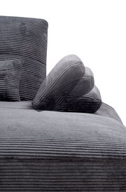 Nahaufnahme einer grauen, gerippten Rundecke mit Kissen, seitliche Perspektive