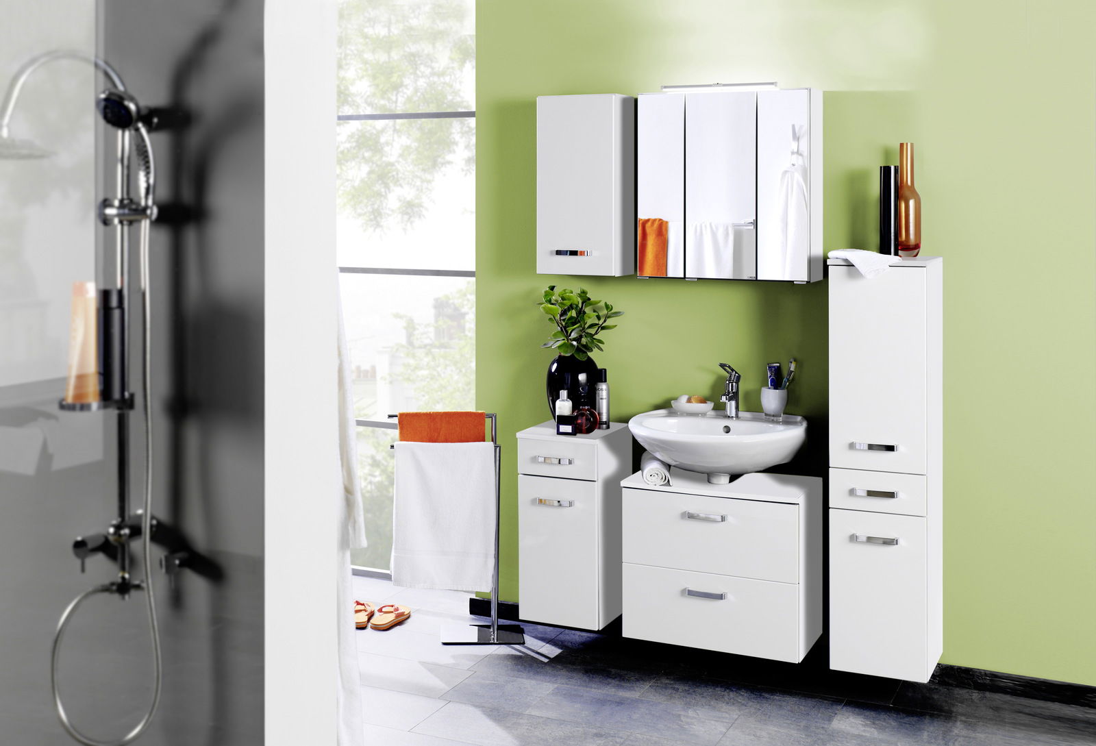 Moderner Spiegelschrank in einem stilvollen Badezimmer mit grüner Wand, Waschbecken und weißen Schränken, aus der Frontalperspektive betrachtet.